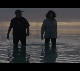 2 people are walking in the beach